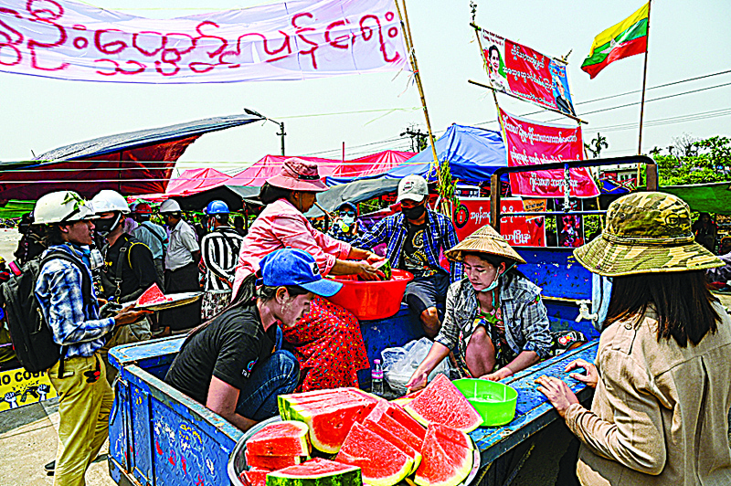 YANGON: People donate watermelons to protesters as they prepare to take part in a demonstration against the military coup in Yangon. - AFPn