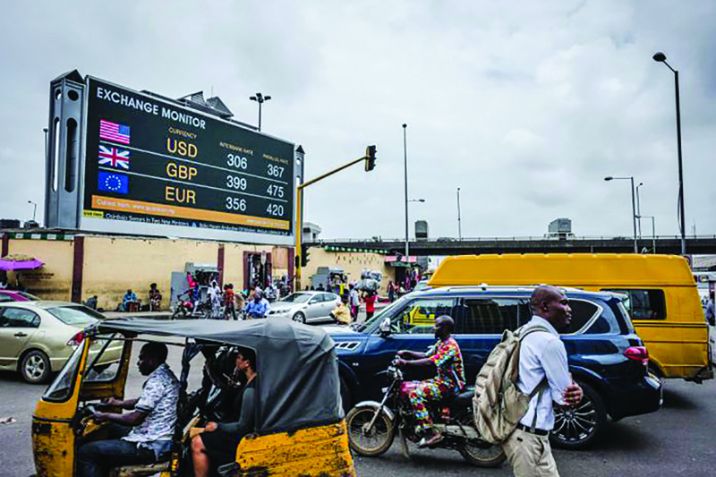 LAGOS: A tuc tuc taxi passes a giant advertising screen showing US dollar, British pound and euro foreign currency exchange rates on a road in Lagos, Nigeria. - AFPnn