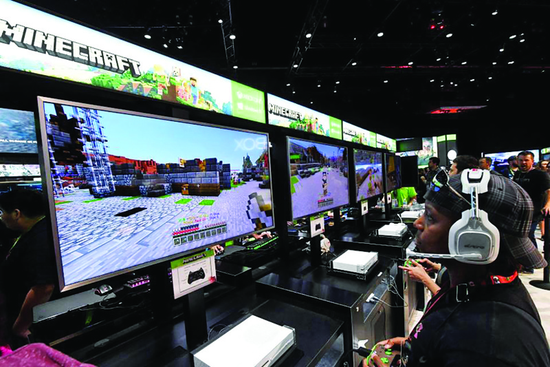 LOS ANGELES: Gamers in the Microsoft Xbox exhibit play the Minecraft game at the Los Angeles Convention center.-AFPn