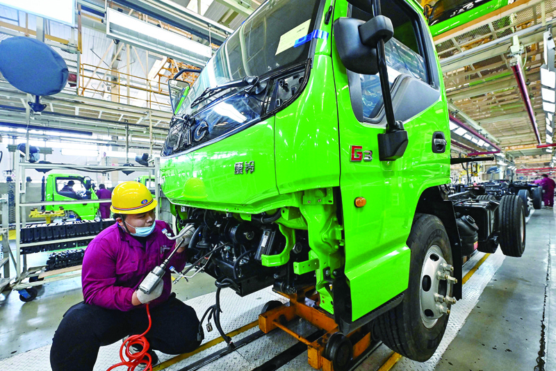 An employee works on a truck assembly line at a factory for the vehicle manufacturing company Jianghuai Automobile Group Corp. (JAC) in Qingzhou in eastern China's Shandong province yesterday.-AFPn