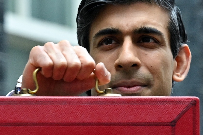 LONDON: Britain's Chancellor of the Exchequer Rishi Sunak poses with the Budget Box as he leaves 11 Downing Street before presenting the government's annual budget to Parliament in London yesterday.-AFPn
