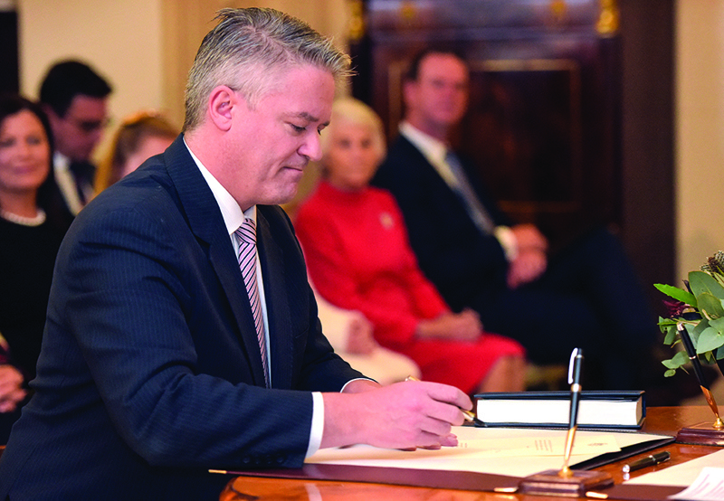 CANBERRA:  In this file photo taken on May 29, 2019 Australian Finance Minister senator Mathias Cormann signs a document during an oath-taking ceremony at Government House in Canberra. - AFPn