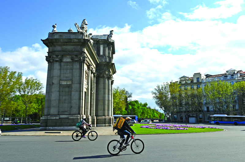 MADRID: In this file photo,  cyclists working for the food delivery services Deliveroo and Glovo ride their bikes in Madrid. - AFPn