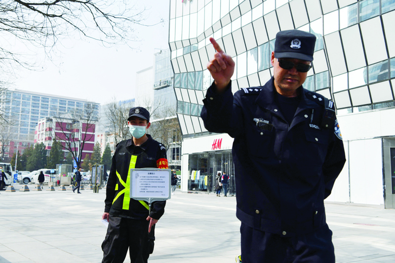 BEIJING: A policeman tries to prevent photos being taken outside a store of Swedish clothing giant H&M in Beijing yesterday after H&M faced calls for a boycott as a backlash brews against Western firms speaking out on human rights. -AFPn