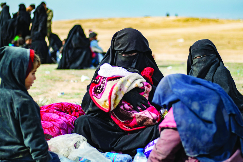 In this file photo, Dorothee Maquere, wife of French jihadist Jean-Michel Clain, sits with four of her five children at a screening area in the eastern Syrian province of Deir Ezzor, after fleeing the Islamic State (IS) group's embattled holdout of Baghouz. - AFPn