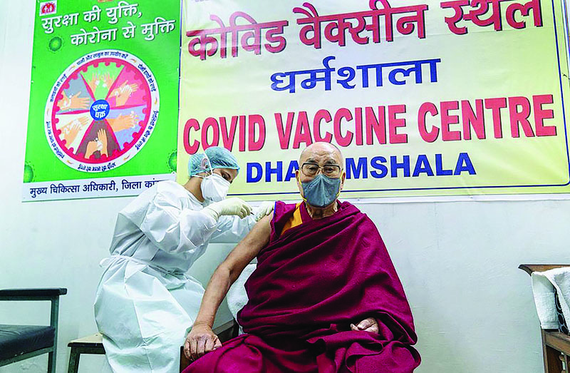 DHARAMSALA, India: Exiled Tibetan spiritual leader Dalai Lama gets inoculated with the COVID-19 vaccine by a health worker at a vaccination center yesterday. - AFP n