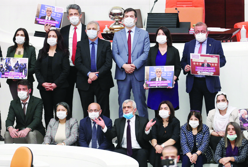 ANKARA: Omer Faruk Gergerlioglu (center front row with a blue mask), a human rights advocate and lawmaker from the People's Democratic Party (HDP) and his colleagues pose after the parliament stripped his parliamentary seat, in Ankara, on Wednesday. - AFPn