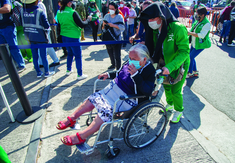 MEXICO CITY: An elderly woman in a wheelchair is assisted before getting vaccinated with a dose of the Pfizer-BioNTech vaccine against COVID-19 at the vaccination center set up at the University City Exhibition Center and Congress in Coyoacan, Mexico City on Wednesday.-AFPn