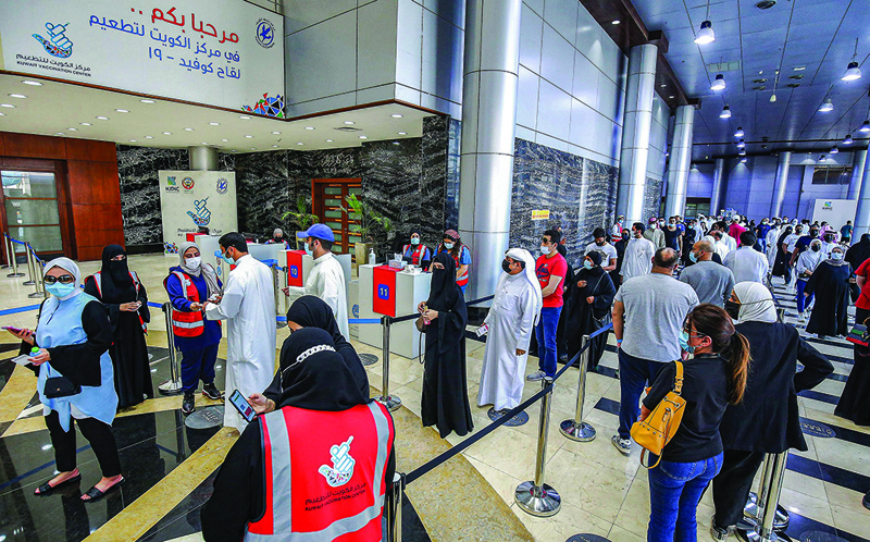 KUWAIT: People queue as they wait to receive a dose of the COVID-19 vaccine at the vaccination center at the international fairgrounds in Mishref yesterday. - Photo by Yasser Al-Zayyatn