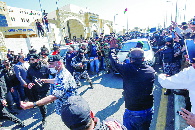 SALT, Jordan: Security forces control the crowd as King Abdullah II arrives in his vehicle at a hospital in this town northwest of Amman yesterday. - AFP n