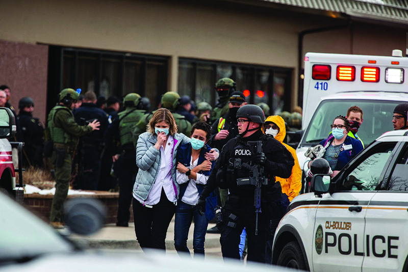 BOULDER: Healthcare workers walk out of a King Sooper's grocery store after a gunman opened fire on Monday. - AFP n