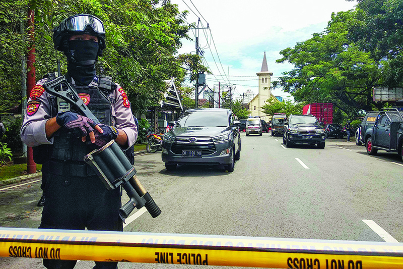 MAKASSAR, Indonesia: An anti-terror policeman stands guard as police seal the area after an explosion outside a church yesterday. - AFP n