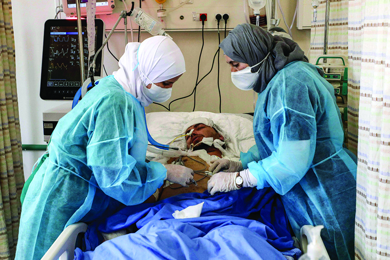 DURA: An intubated COVID-19 coronavirus disease patient receives an injection while lying in an intensive care unit of Dura Public Hospital west of Hebron on Tuesday. - AFP n