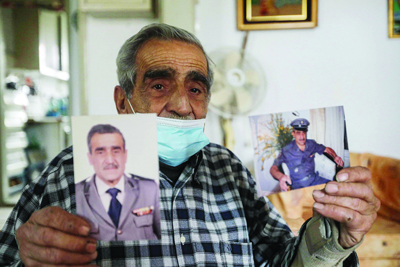BEIRUT: Jean Assaf, an 80-year-old retired police officer, shows old pictures of him in uniform at his home in the capital's Mar Mikhael district on March 24, 2021. - AFP n