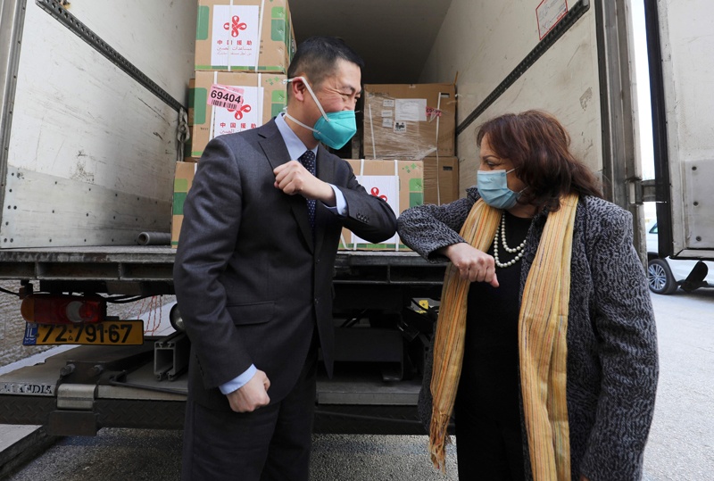 RAMALLAH: Chinese Ambassador Guo Wei and Palestinian Health Minister Mai Al-Kaila bump elbows during the unloading of a shipment of Sinopharm COVID-19 vaccines donated by the Chinese government yesterday. - AFP  n