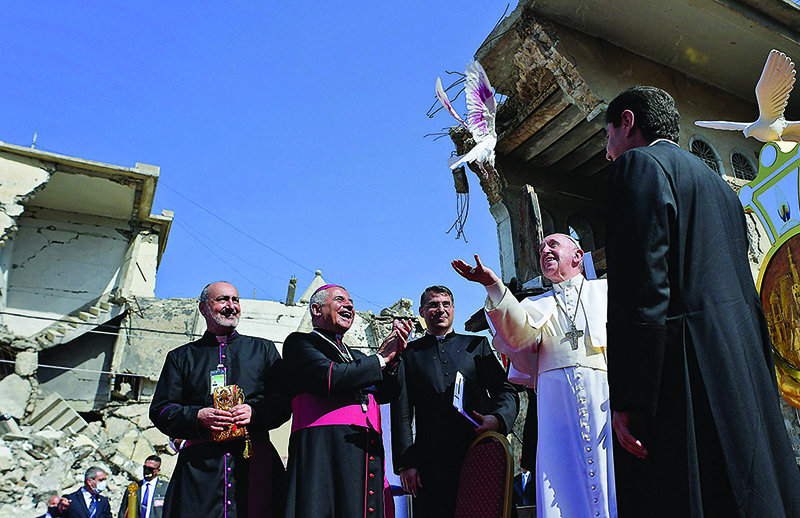 MOSUL: Pope Francis releases a white dove at a square near the ruins of the Syriac Catholic Church of the Immaculate Conception (Al-Tahira-l-Kubra) in the old city of Mosul yesterday. —  AFP