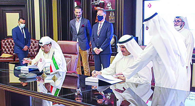 KUWAIT: Sheikh Salman Al-Hmoud Al-Sabah (right) and Sami Al-Amer sign the deal. - KUNAnnnnn