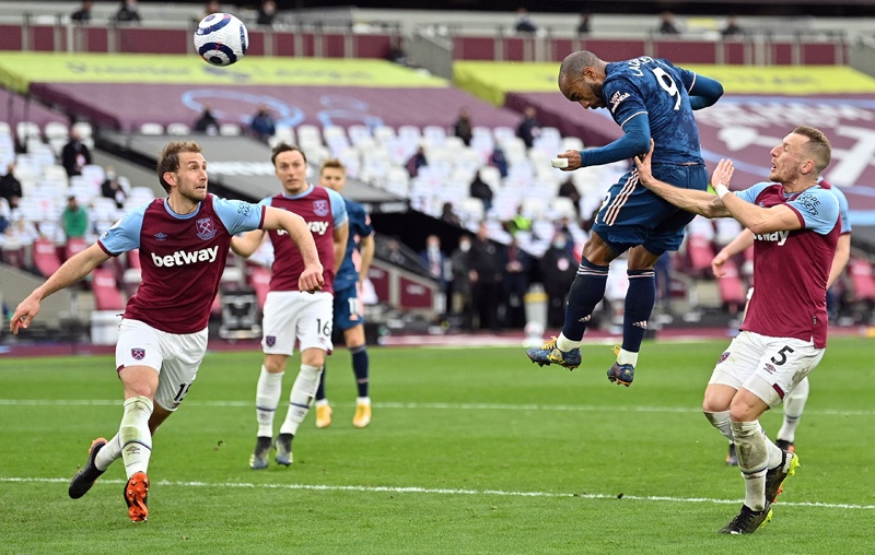 LONDON: Arsenal's French striker Alexandre Lacazette scores his team's third goal during the English Premier League football match between West Ham United and Arsenal at The London Stadium yesterday. - AFP n