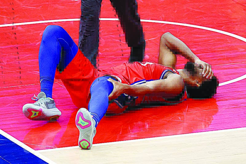WASHINGTON: Joel Embiid of the Philadelphia 76ers reacts after getting injured in the second half against the Washington Wizards at Capital One Arena on Friday in Washington, DC. - AFPn