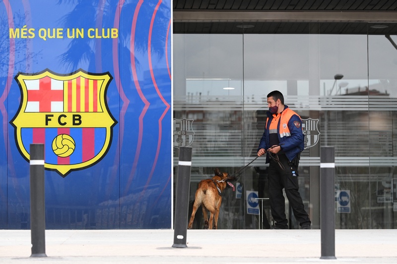 BARCELONA: A security guard enters the offices of Barcelona Football Club with a dog yesterday in Barcelona during a police operation inside the building. – AFPn