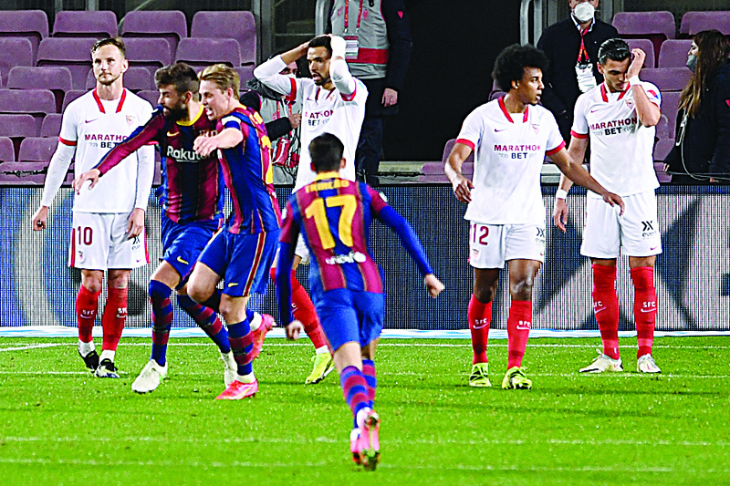 BARCELONA: Barcelona's Spanish defender Gerard Pique (second left) celebrates after scoring his team's second goal during Spanish Copa del Rey (King's Cup) semi-final second leg football match between FC Barcelona and Sevilla FC at the Camp Nou stadium in Barcelona on Wednesday. - AFPn