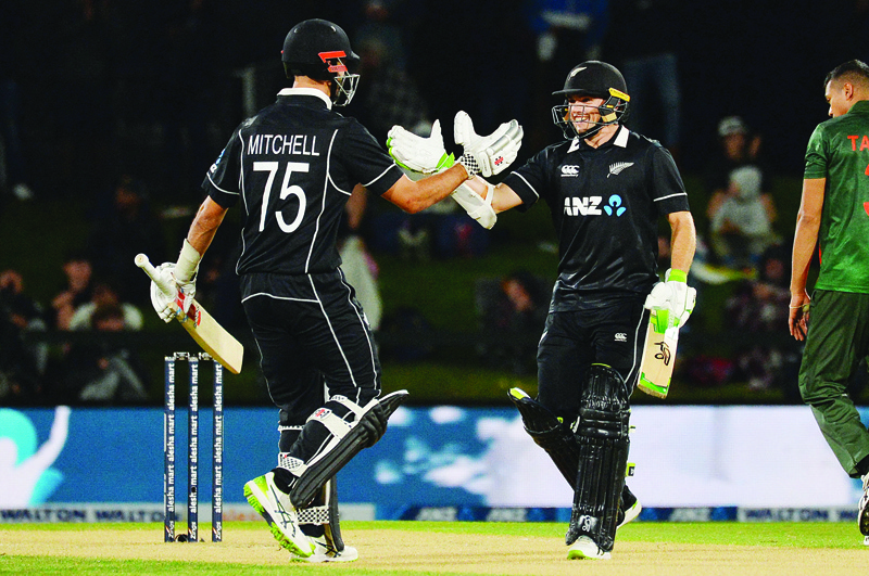 CHRISTCHURCH: New Zealand's Tom Latham (right) is congratulated by teammate Daryl Mitchell after scoring a century during the second one-day international (ODI) cricket match between New Zealand and Bangladesh at the Hagley Oval in Christchurch yesterday. - AFPn