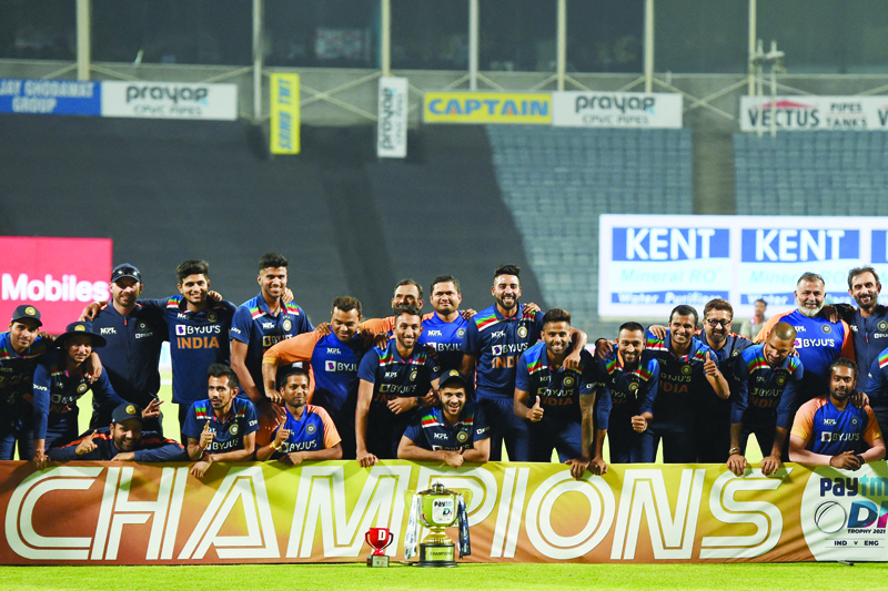 PUNE: Members of Indian cricket team pose with the trophy after winning the one-day international (ODI) series against England at the end of their third and final ODI cricket match at the Maharashtra Cricket Association Stadium in Pune on Sunday. - AFPn
