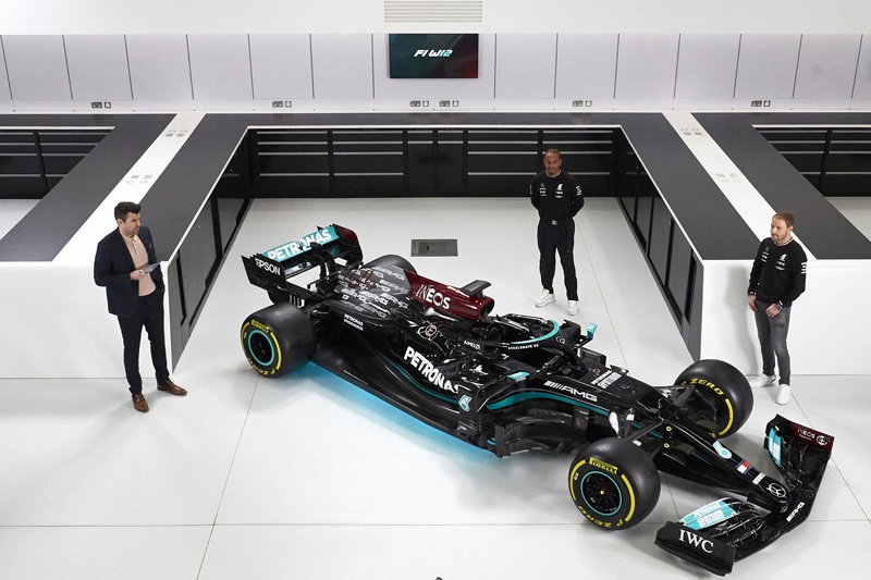 BRACKLEY: A handout photograph released by Mercedes-AMG Petronas F1 Team on Tuesday shows British driver Lewis Hamilton (center) and Finish driver Valtteri Bottas (right) posing with the Mercedes-AMG F1 W12 E Performance car during a launch event in Brackley, central England. - AFPn