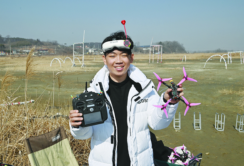 HWASEONG: This picture taken on February 20, 2021 shows Kang Chang-hyeon, a teenaged drone-racing champion, posing with his drone during a training session at a rice field in Hwaseong, south of Seoul. - AFPn