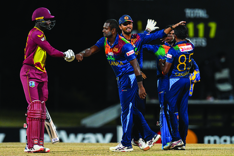 ST JOHN'S, ANTIGUA AND BARBUDA: Kevin Sinclair (left) of West Indies congratulate Angelo Mathews (2nd L) as Dinesh Chandimal (second right) and Lakshan Sandakan (right) of Sri Lanka celebrate winning the 2nd T20i match between Sri Lanka and West Indies at Coolidge Cricket Ground on Friday in Osbourn, Antigua and Barbuda. - AFPn