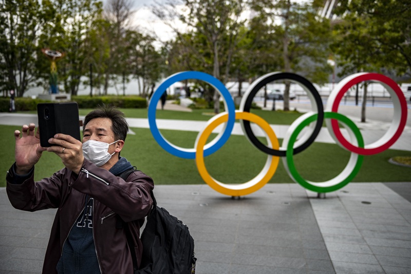 TOKYO: A man takes pictures in front of the Olympic Rings outside the Japan Olympic Museum in Tokyo yesterday. - AFPn