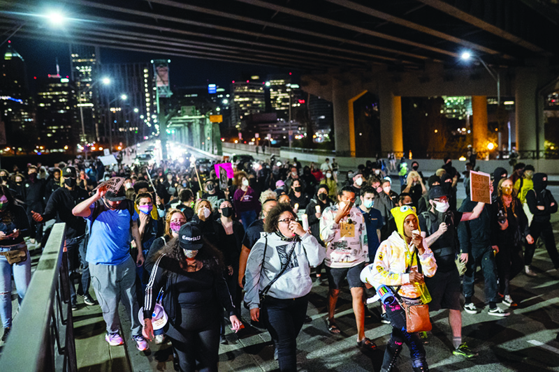 PORTLAND, OR: Protesters march along the Hawthorne Bridge following the police shooting of a homeless man in Lents Park Friday in Portland, Oregon. —AFP