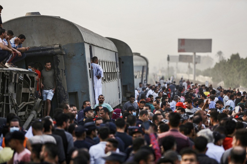 People gather by an overturned train carriage at the scene of a railway accident in the city of Toukh in Egypt's central Nile Delta province of Qalyubiya Sunday.-AFPn