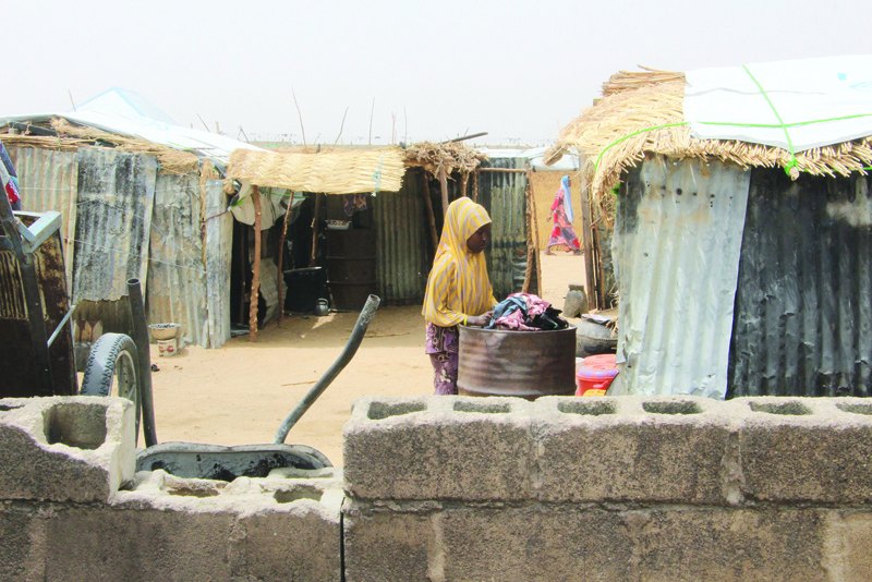 MAIDUGURI, Nigeria:  A woman stands between structures Yawuri informal camp on the outskirts of Maiduguri, capital of Borno state. The makeshift camp hosts nearly 2,000 people internally displaced by a decade-long jihadist insurgency in northeast Nigeria. - AFPn