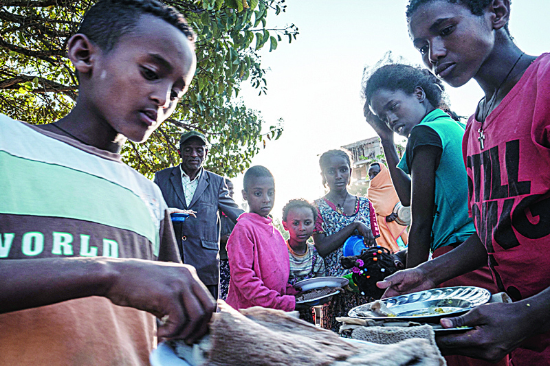 MEKELE: Displaced children from Western Tigray wait at meal time to receive food outside a classroom in the school where they are sheltering in Tigray's capital Mekele. - AFPn