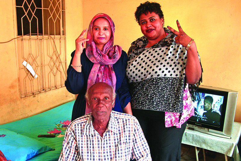 KHARTOUM: Amin Israil (bottom), the grandson of an Iraqi Jew who settled in Sudan and whose family later converted to Islam, his daughter Salma (left), and Yosar Basha (right), another Sudanese woman descended of Jewish origins, pose for a photo together at Israil's home during an interview. - AFPn