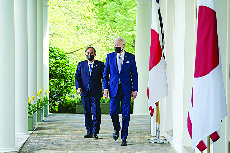 WASHINGTON: US President Joe Biden and Japan’s Prime Minister Yoshihide Suga walk through the Colonnade to take part in a joint press conference in the Rose Garden of the White House in Washington, DC on Friday. —AFP