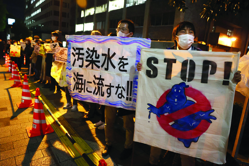 TOKYO: Protestors hold slogans as they take part in a rally against the Japanese government's decision to release treated water from the stricken Fukushima Daiichi nuclear plant into the sea, outside of the prime minister's office in Tokyo yesterday.-AFPn