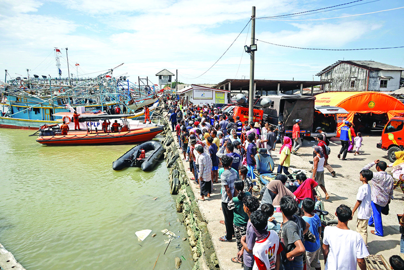 People crowd along a dock as rescue efforts prepare to head out to search for 17 fishermen who went missing after two boats collided the night before in waters off Indramayu, West Java province yesterday.-AFPn