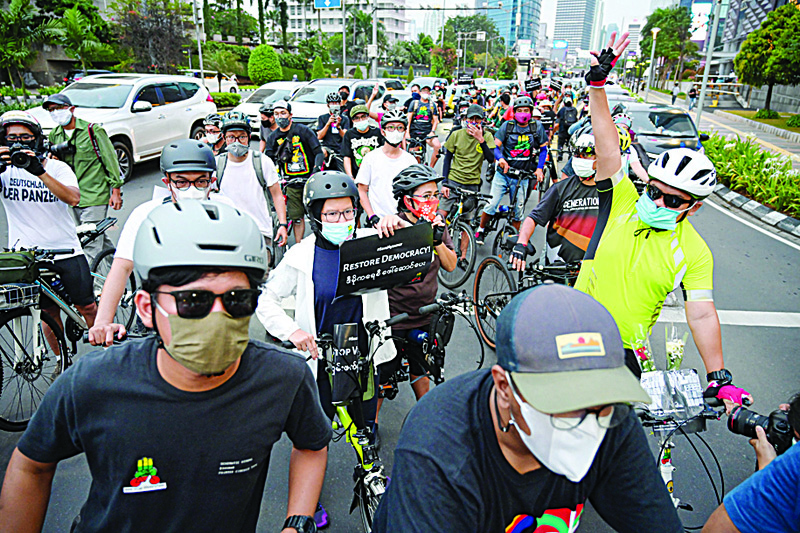 JAKARTA: Indonesian cyclists take part in a rally to show their their support for democracy in Myanmar near the Myanmar embassy in Jakarta.-AFPn