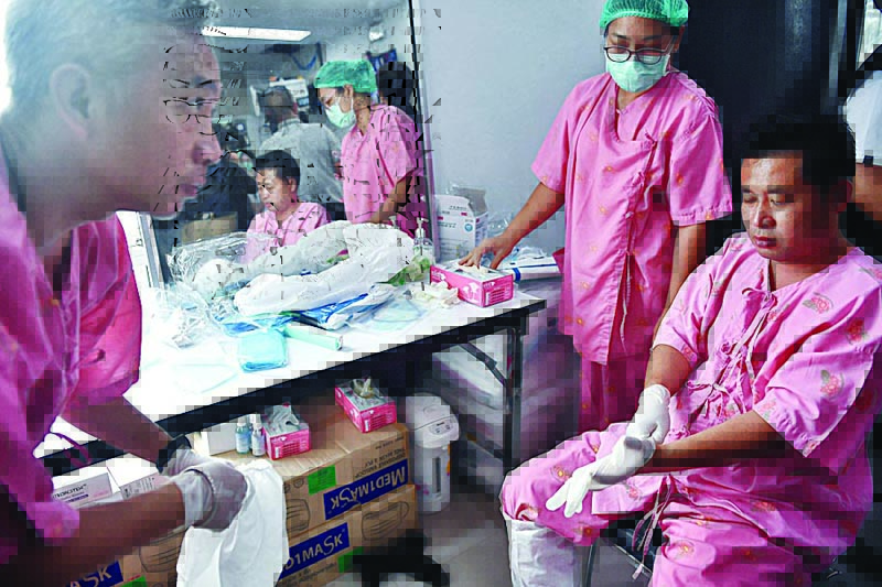 BANGKOK: Health workers put on full personal protective equipment (PPE) before going inside a COVID-19 field hospital, recently set up to combat the spread of the novel coronavirus, on the outskirts of Bangkok on Saturday.—AFPn