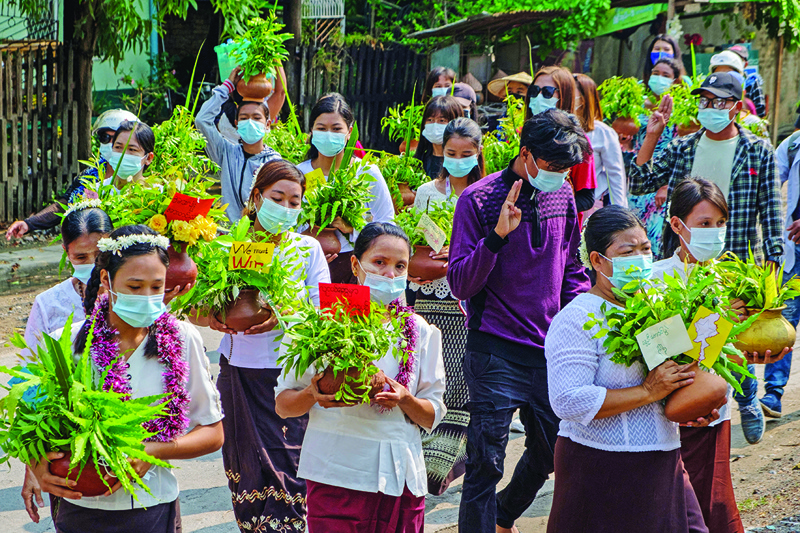 MANDALAY: This photo taken and received courtesy of an anonymous source yesterday shows protesters carrying A-taui pots filled with Thingyan festival flowers while taking part in a demonstration against the military coup in Mandalay. -- AFPn