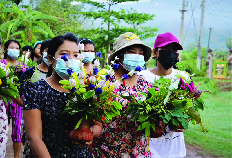 This handout photo taken and released by Dawei Watch yesterday shows protesters carrying pots filled with Thingyan festival flowers and leaves during a demonstration against the military coup in Dawei. - AFPn