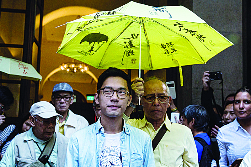 Pro-democracy activist Nathan Law (center left) walking past the media outside the Court of Final Appeal after his bail application was successful in Hong Kong in this file photo.-AFPn