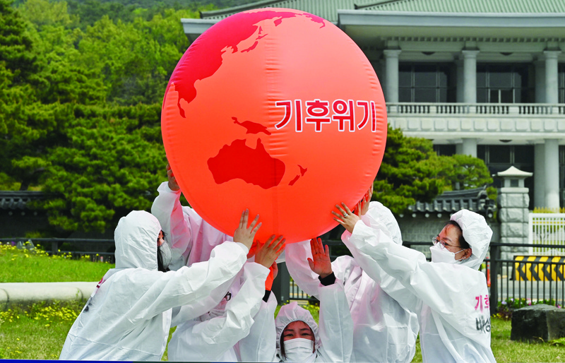 SEOUL: Environmental activists take part in an Earth Day rally against climate change near the presidential Blue House yesterday. - AFP n