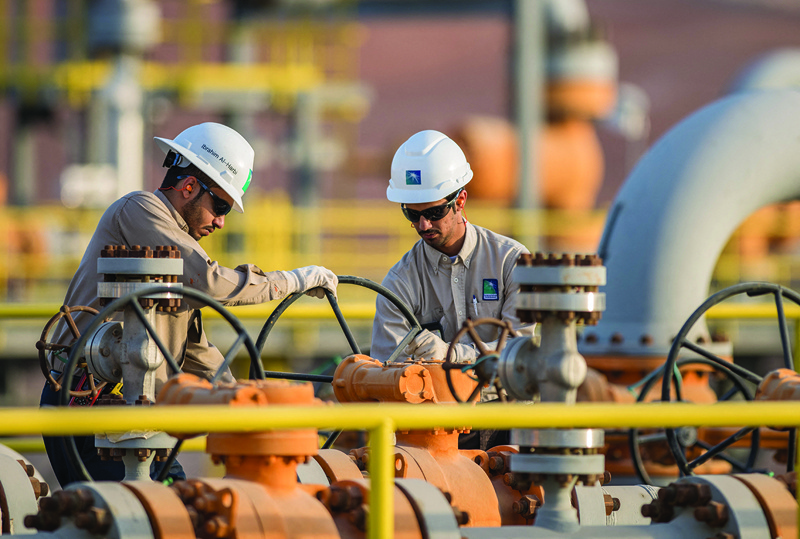 Aramco engineers working in eastern Saudi Arabi. Energy giant Saudi Aramco said it has struck a $12.4-billion deal to sell a minority stake in a newly formed oil pipeline business to a consortium led by US-based EIG Global Energy Partners. -- AFPn