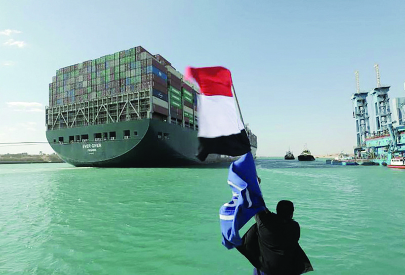 ISMAILIA, Egypt: A man waves the Egyptian flag after Panama-flagged MV 'Ever Given' container ship was fully dislodged from the banks of the Suez Canal on March 29, 2021. - AFP n