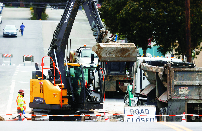 SAN FRANCISCO:: Workers operate an excavator as they make infrastructure repairs on Wednesday. April 07, 2021 in San Francisco, California. President Biden last week unveiled a $2 trillion jobs and infrastructure plan paid for in part by an increase in the domestic corporate tax rate, and by sweeping up corporate profits stashed overseas. - AFPn