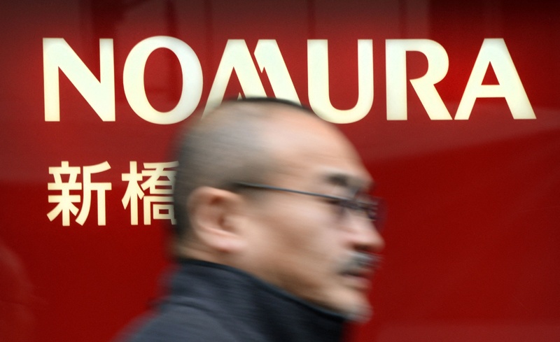 A man passes before a branch of Japanese securities company Nomura Securities in Tokyo. - AFP