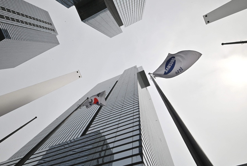 A Samsung flag (R) and South Korean national flag flutter at the company's Seocho building in Seoul. - AFP